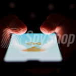 Close-up of the phone screen with 5G network signage. Hands visible above it, the background is dark.