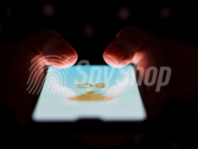 Close-up of the phone screen with 5G network signage. Hands visible above it, the background is dark.