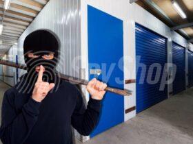 A masked burglar holding a crowbar inside a storage facility, symbolizing the risk of storage unit break-ins and the importance of security measures.