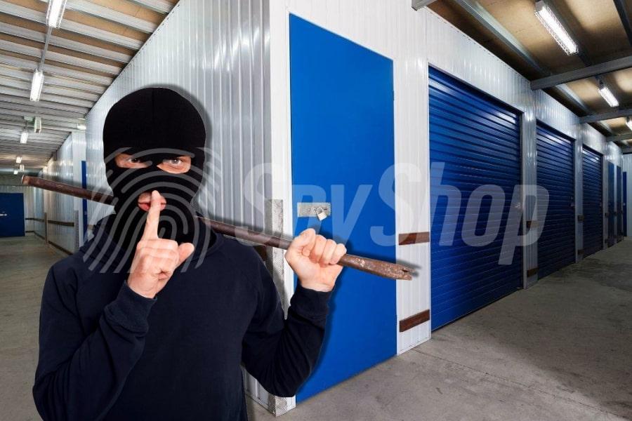 A masked burglar holding a crowbar inside a storage facility, symbolizing the risk of storage unit break-ins and the importance of security measures.