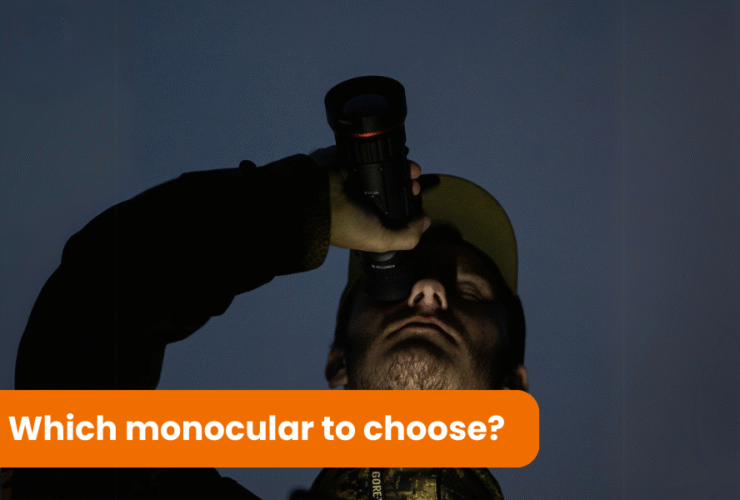 A man wearing a cap is holding a monocular and looking through it into the darkness. It is the middle of the night.
